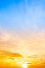 Fototapeta premium Sky sunset,Beautiful sunrise sky with vibrant gradient orange and gold colors and soft blue, Clear atmosphere with wispy clouds. Peaceful, perfect for background and copy space, vertical