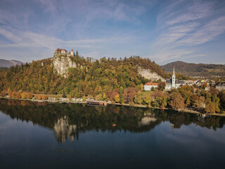 Fototapeta premium Bled Castle and Assumption of Mary Church Reflecting on Lake Bled in Autumn