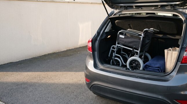 Folded Wheelchair in the Open Boot of a Grey Hatchback Car