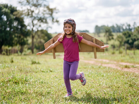 Creative young child playing with cardboard toy and pretending to live an adventure