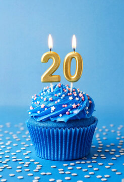 Blue cupcake with lit candles celebrating twentieth birthday occasion