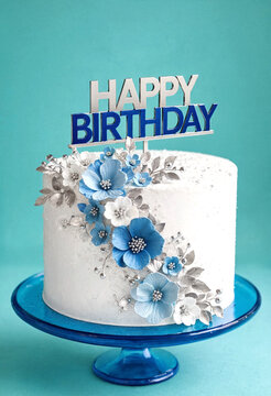 Elegant birthday cake decorated with blue flowers and silver accents
