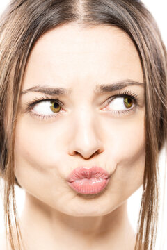 A close-up shot of a woman contorting her face into a funny expression, showcasing humor and amusement.