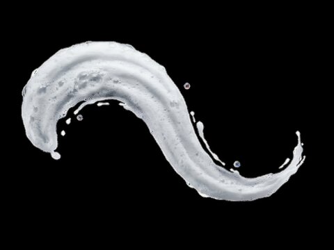 Sshaped smear of white soapy foam with small bubbles, isolated on black
