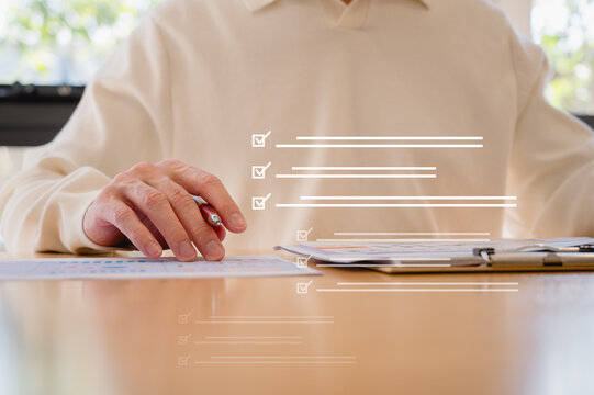 Businessman using pen, completing checklist on document in data system Report HR technology Concept, A checklist for policy implementation featuring a standard and official approved documents