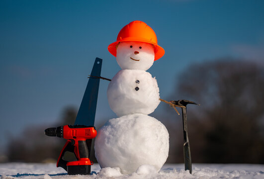 Snowman builder with construction tools. Winter snowman worker. Snow man engineer with hardhat. Funny snowman builder. Snowman construction worker with tools. Snow man on winter project.