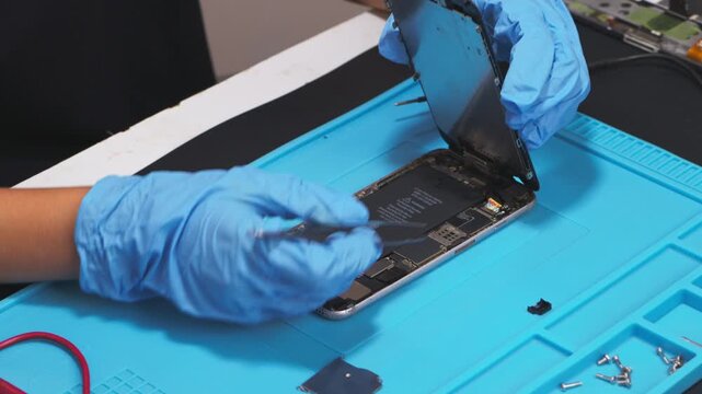 Female technician replaces smartphone lithium battery for hardware repair concept. Conceptual backdrop for phone repair service, right to repair microelectronics, and green circular economy 