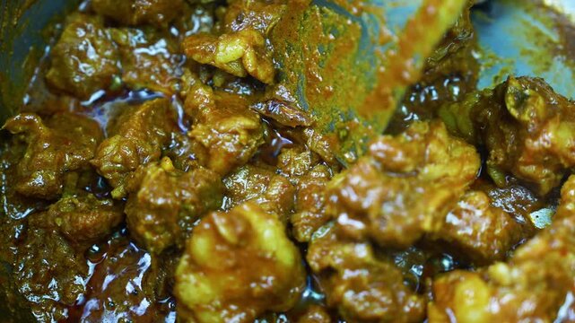 Close-up of chunky homemade curry in rich sauce, Close-up view of chunky homemade curry simmered in a rich brown sauce with herbs, spices, and glistening oil