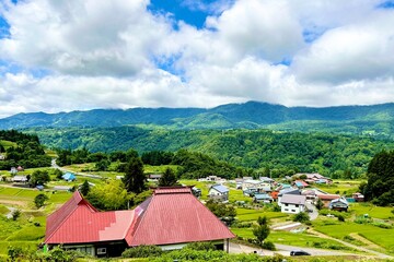 Rural landscape of NOZAWA ONSEN Village with mountains,traditional house,and blue sky in NOZAWA,japan 日本の長野県にある野沢温泉村の、山々、伝統な家々、青空が広がるのどかな風景 © ERIKO