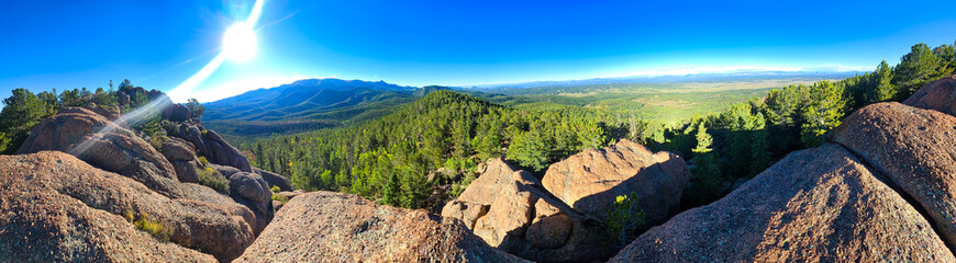 Fototapeta premium Panoramic Mountain Vista with Sunlit Rock Formations