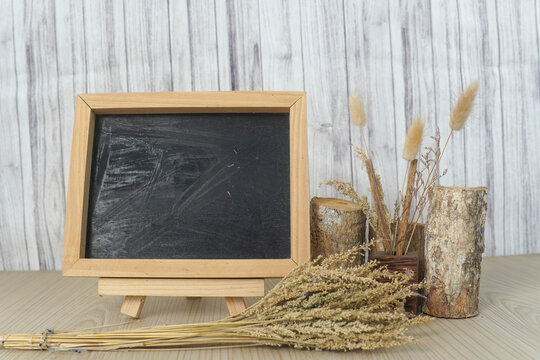 Small blank chalkboard on a wooden easel with dried wheat and birch decor
