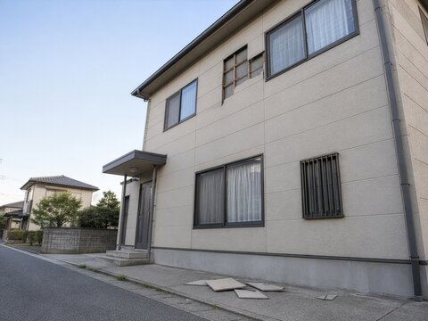 外壁材が剥がれ地面に落ちた戸建て住宅