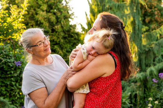 Three Generations Sharing Tender Family Moment in Summer Garden