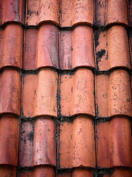 Close-up of Weathered Terracotta Roof Tiles Showing Rustic Texture and Overlapping Patterns.