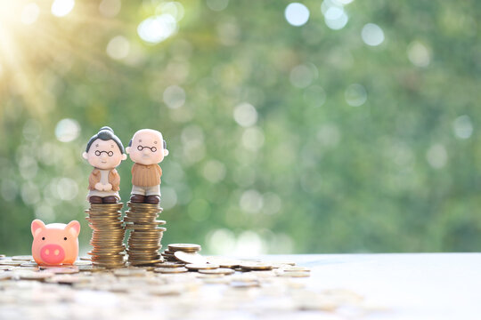 Mutual fund,Happy senior couple figurines sitting and a growing stack of coins, Symbolizing successful retirement planning and long-term financial security for old age.