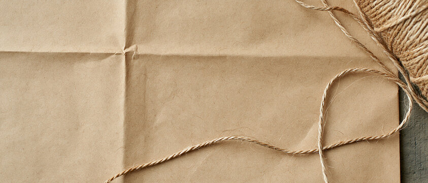Brown Paper Package Tied with Twine String on Wooden Surface