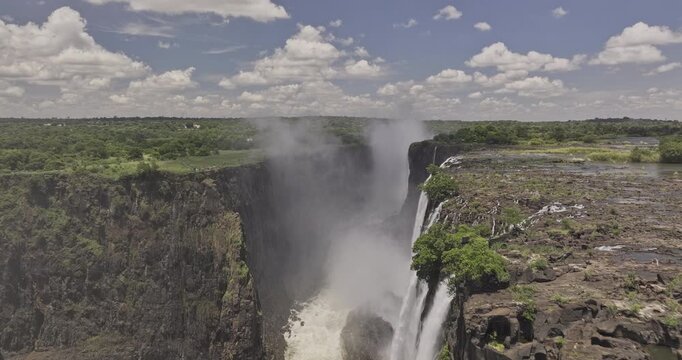 Victoria Falls Zimbabwe Aerial v22 low flyover capturing Mosi-oa-Tunya, Zambezi river water plunging into the deep gorge, and creating a massive mist plume - Shot with 5k Camera - Jan 3rd 2024