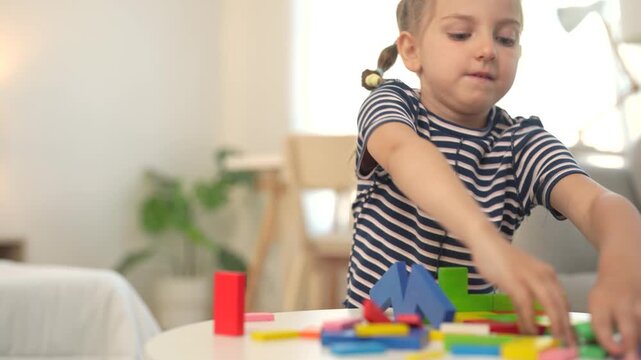 Young girl plays independently with colorful building blocks at home, arranging pieces during creative play, learning activity, childhood development, imagination.