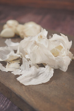 Garlic cloves and peels on a wooden surface during food preparation