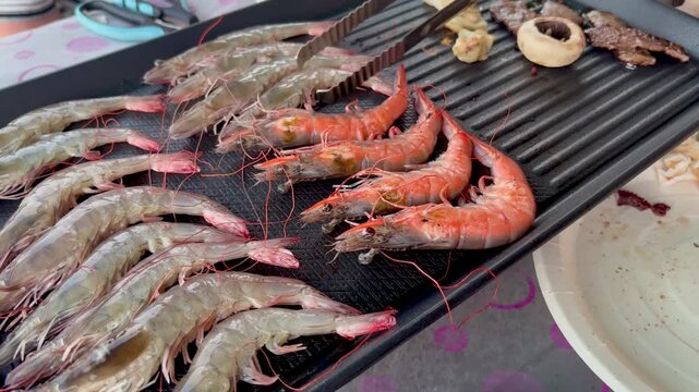 Grilling fresh shrimp on a hot sizzling pan or grill