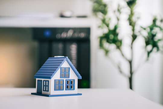 Model house representing real estate investment on white table with office background for mortgage property loan concept