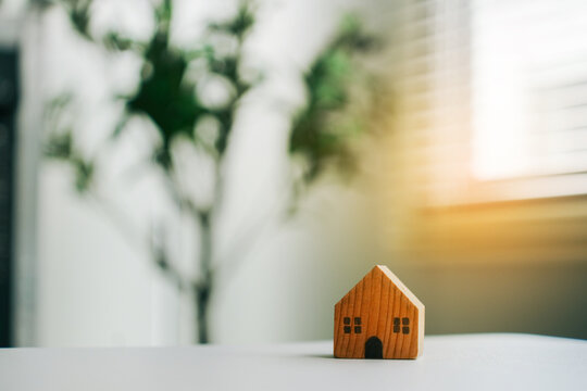 Wooden house model on table for mortgage loan, real estate investment and financial home planning strategy
