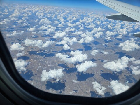 Aerial landscape view from airplane window with clouds
