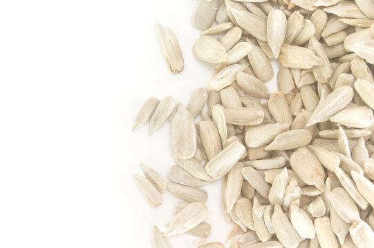 Shelled sunflower seeds on white background with copy space