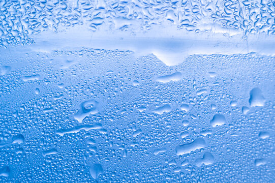 Large water drops and condensation on blue surface macro