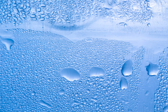 Large water drops on blue condensation background macro