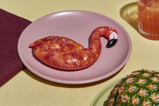 Surreal flamingo float food hybrid on a pink plate with pineapple and cocktail, featuring rich textures for hospitality and catering ads