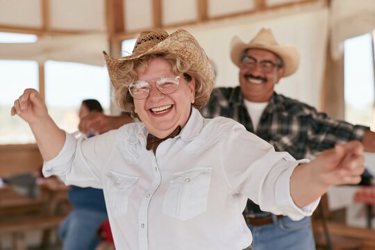 Group of women and men dancing a line dance in a rustic country bar, natural and joyful moment for business and human services