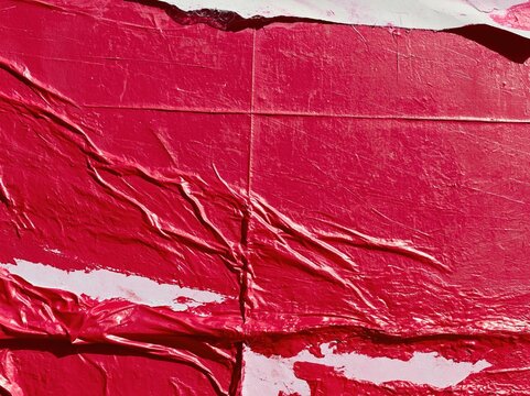 Wheat paste poster texture with wrinkled fuchsia paper, featuring crinkled ridges and a glossy sheen for urban street campaign mockups