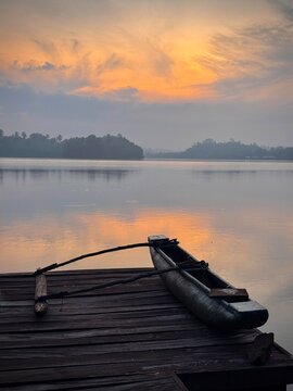 Traditional outrigger canoe on wooden dock at sunset, Sri Lanka