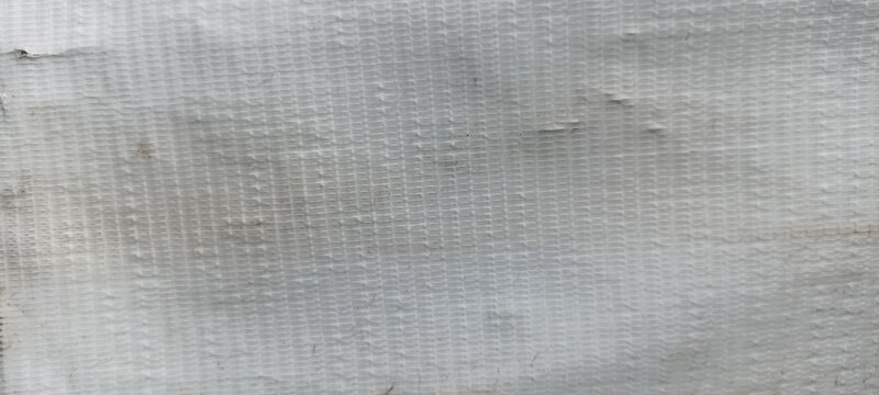 White woven plastic tarp texture background, macro pattern of poly woven fabric surface