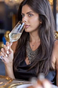Close up of elegant woman sipping champagne at high end restaurant