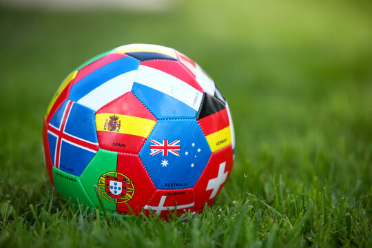 Soccer ball with various flags on the grass