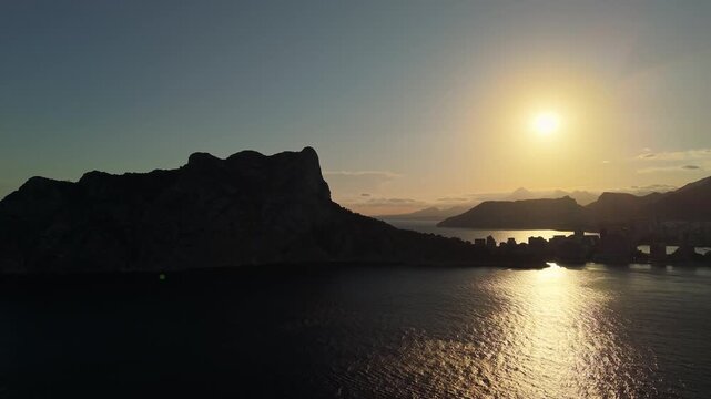 Aerial sunset panorama over Calpe and Penon de Ifach rock formation in Mediterranean sea Spain.