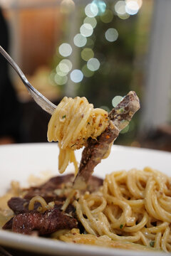 Italian gourmet steak cream spaghetti garnished with herbs, close up look
