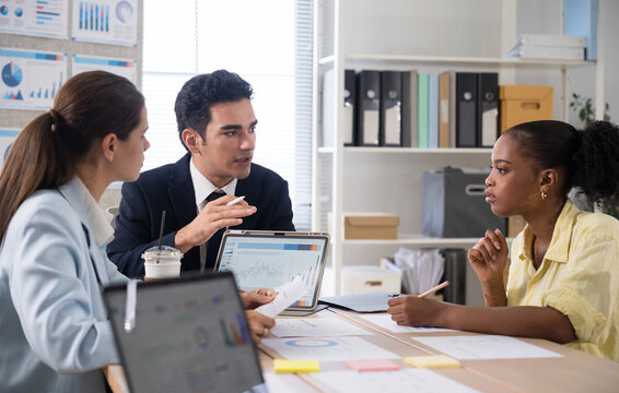 Business team discussing financial charts and data on a digital tablet during a meeting in a modern office corporate strategy, and teamwork.