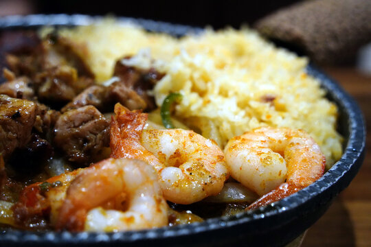 Macro shot of seasoned grilled shrimp on a sizzling mexican fajita platter