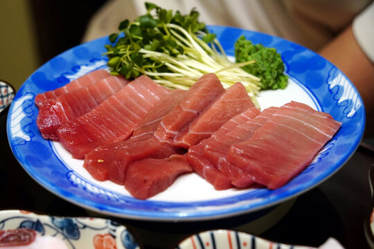 Premium bluefin tuna sashimi slices served on a blue pattern plate
