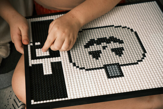 Child Building Pixel Art Mosaic Puzzle Board