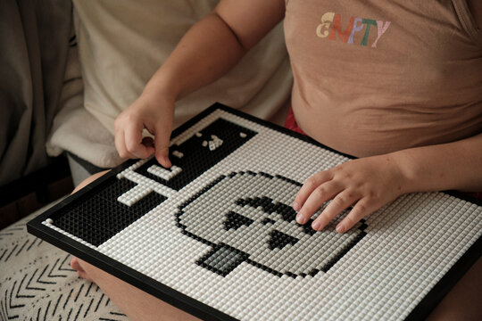 Child Building Pixel Art Mosaic Puzzle Board