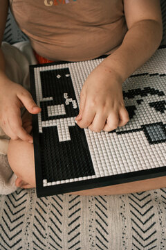 Child Building Pixel Art Mosaic Puzzle Board