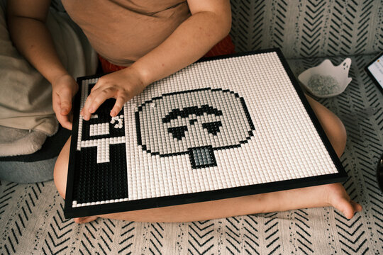Child Building Pixel Art Mosaic Puzzle Board