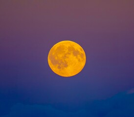 Orange moon against red and purple sky © Rich