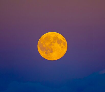 Orange moon against red and purple sky