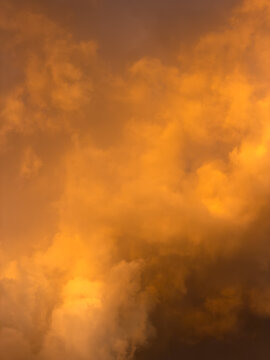 Warm, golden clouds glow against dusky sky