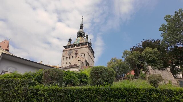 Sighisoara Clock Tower rising above gardens in the medieval Old Town of Transylvania Romania